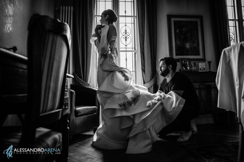 Simone Marulli aiuta la sposa ad indossare uno dei suoi abiti.